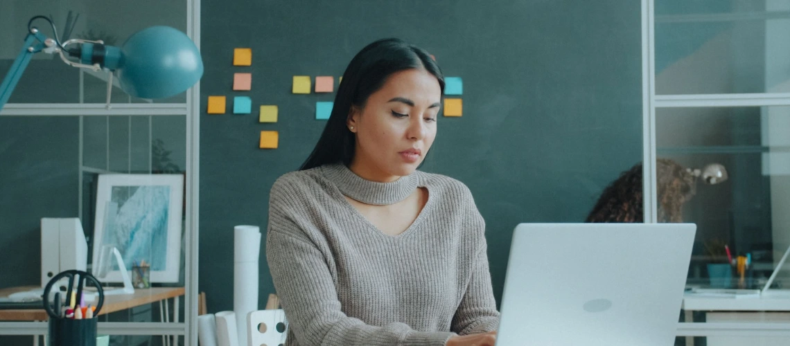 Woman working on a laptop while editing keywords in a LaTeX document